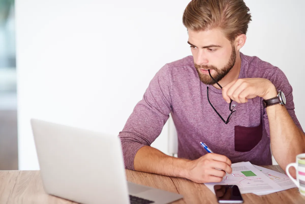 Ung mand analyserer budget og investeringer på sin bærbare computer